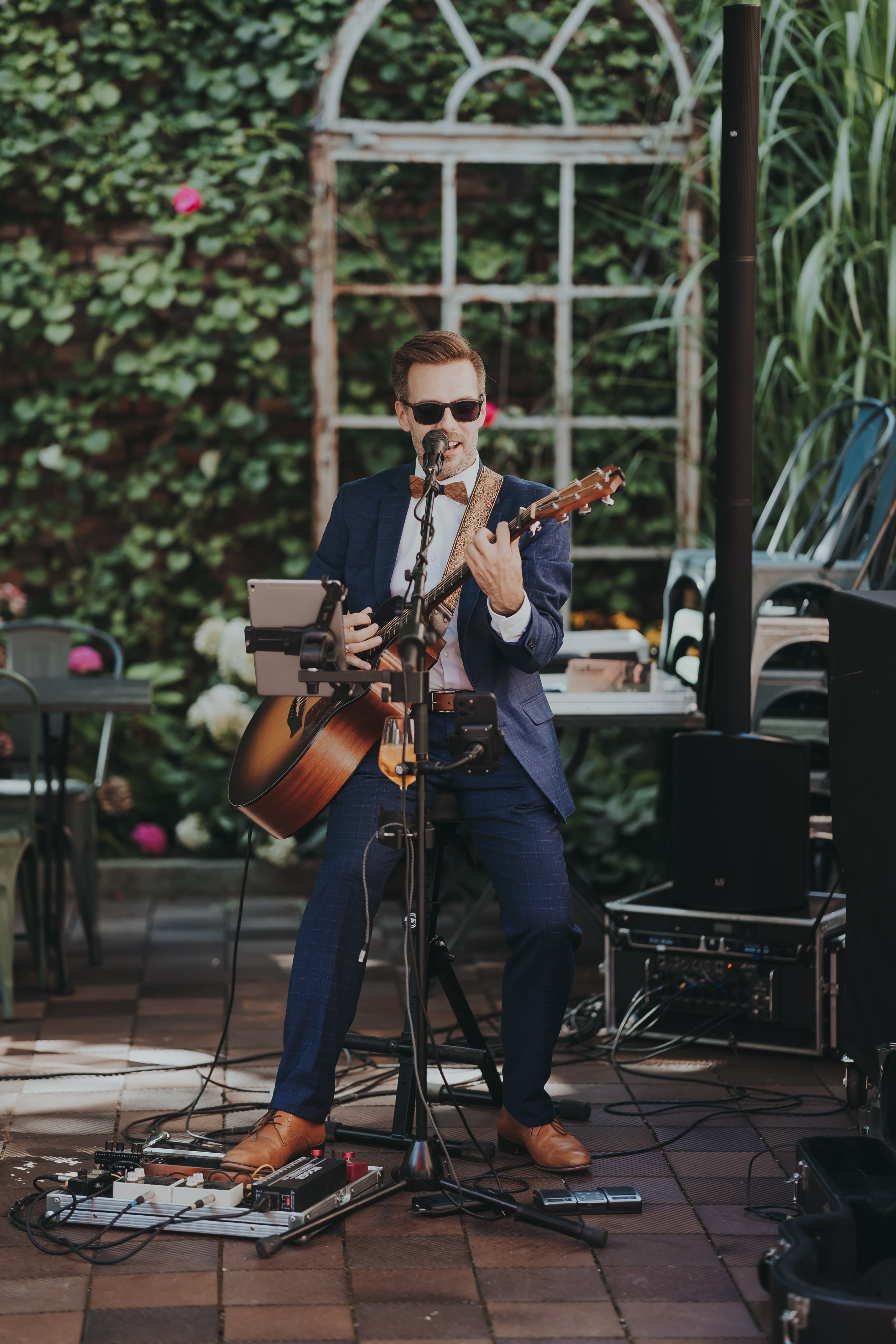 Live-Musiker mit Gitarre vor grüner Kulisse