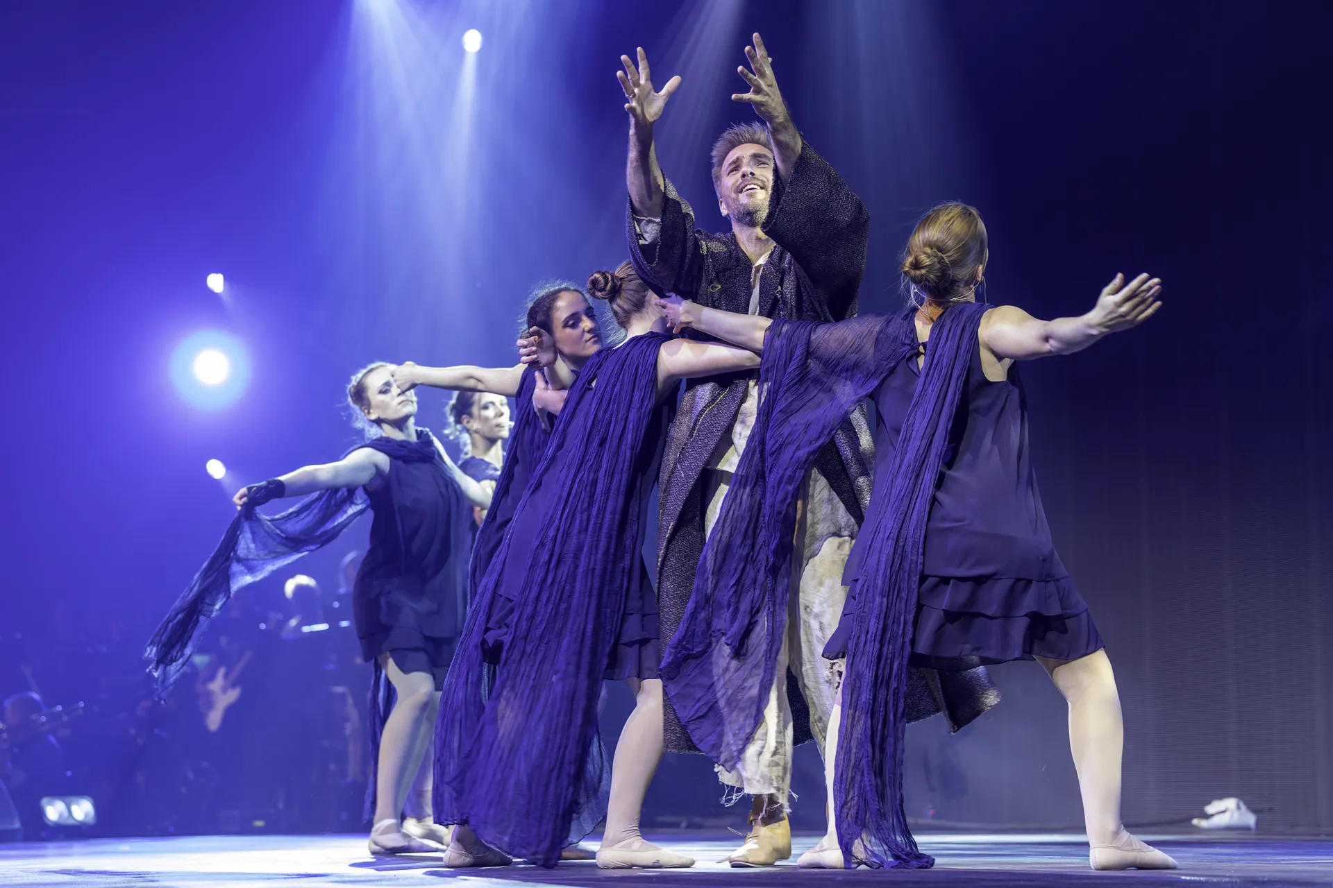 Danny Barlhow in HERILO 2025 mit Ensemble und blauem Bühnenlicht